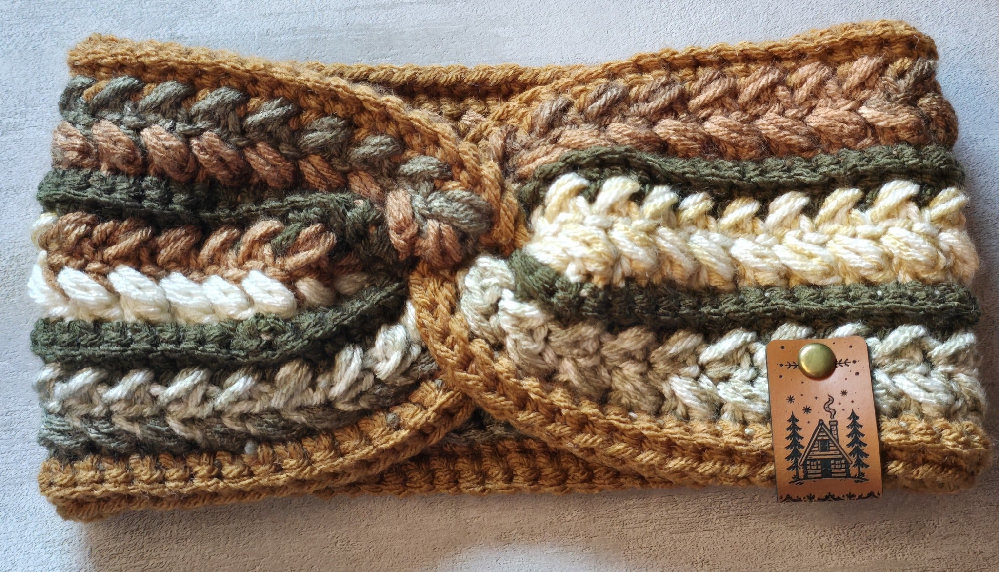 Handmade wheat stitch earwarmer in earthy colors with a cabin tag