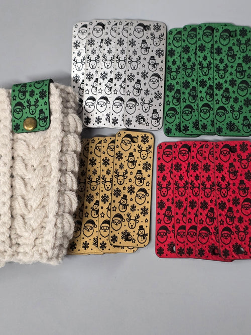 Christmas fold-over tags in four colors beside a green tag attached to cream crochet fabric.