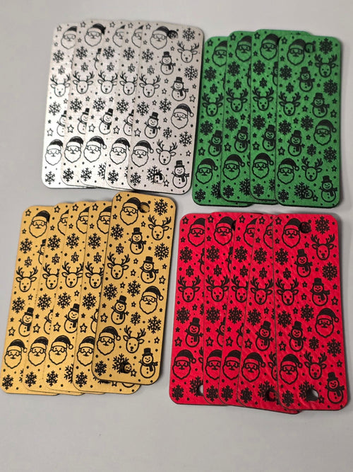 Set of 20 Christmas faux leather fold-over tags in silver, green, gold, and red, engraved in black with Santa faces, snowmen, reindeer, and snowflakes.