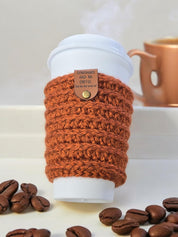 Dinosaurs had no coffee tag attached to a rust crochet cup cozy