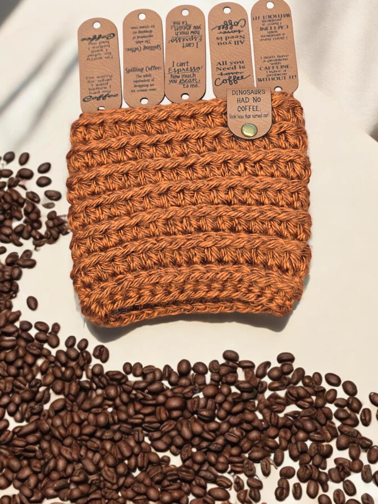 Coffee quote fold-over tags on a rust crochet cup cozy