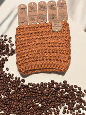 Coffee quote fold-over tags on a rust crochet cup cozy
