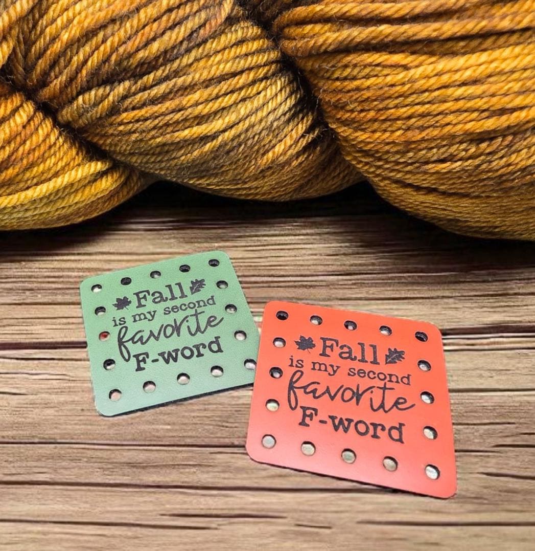 Green and orange Fall Is My Second Favorite F Word square sew-on faux leather patches beside autumn yarn