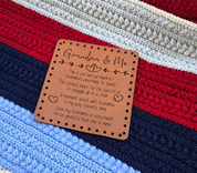 Illustrative close-up mockup of Grandma & Me patch resting on a striped crochet blanket