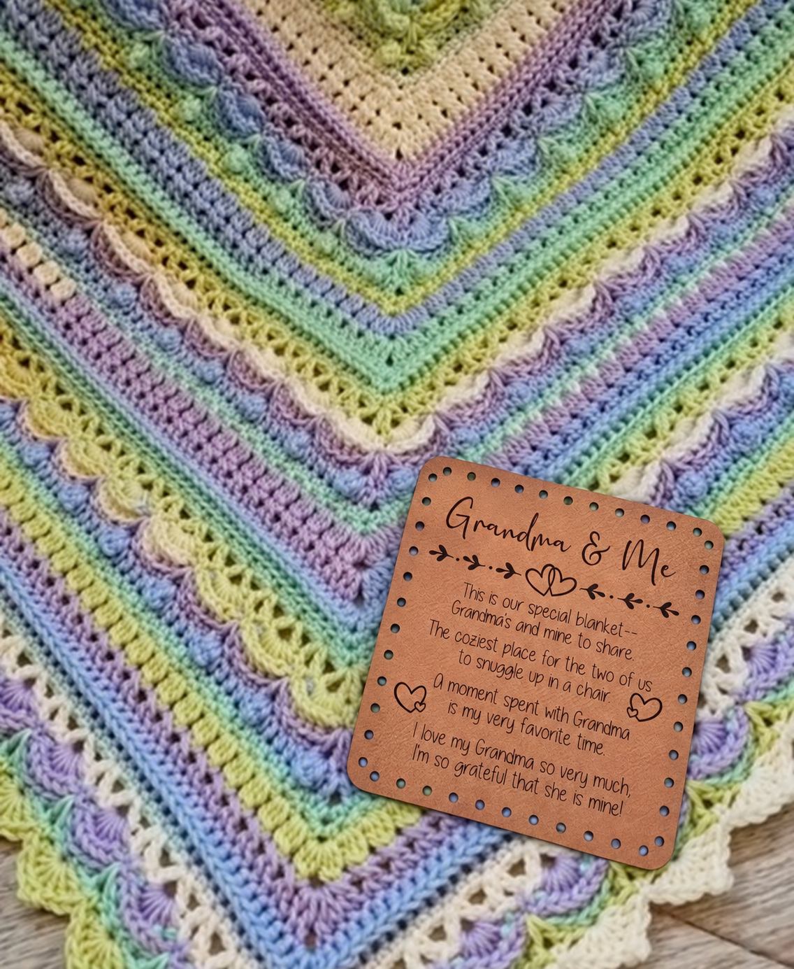 Illustrative mockup of Grandma & Me patch resting on a pastel crochet blanket