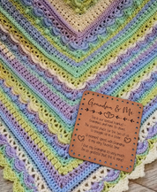 Illustrative mockup of Grandma & Me patch resting on a pastel crochet blanket