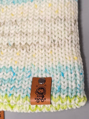 Close-up of a rivet-fastened kids animal tag on a pastel knitted beanie
