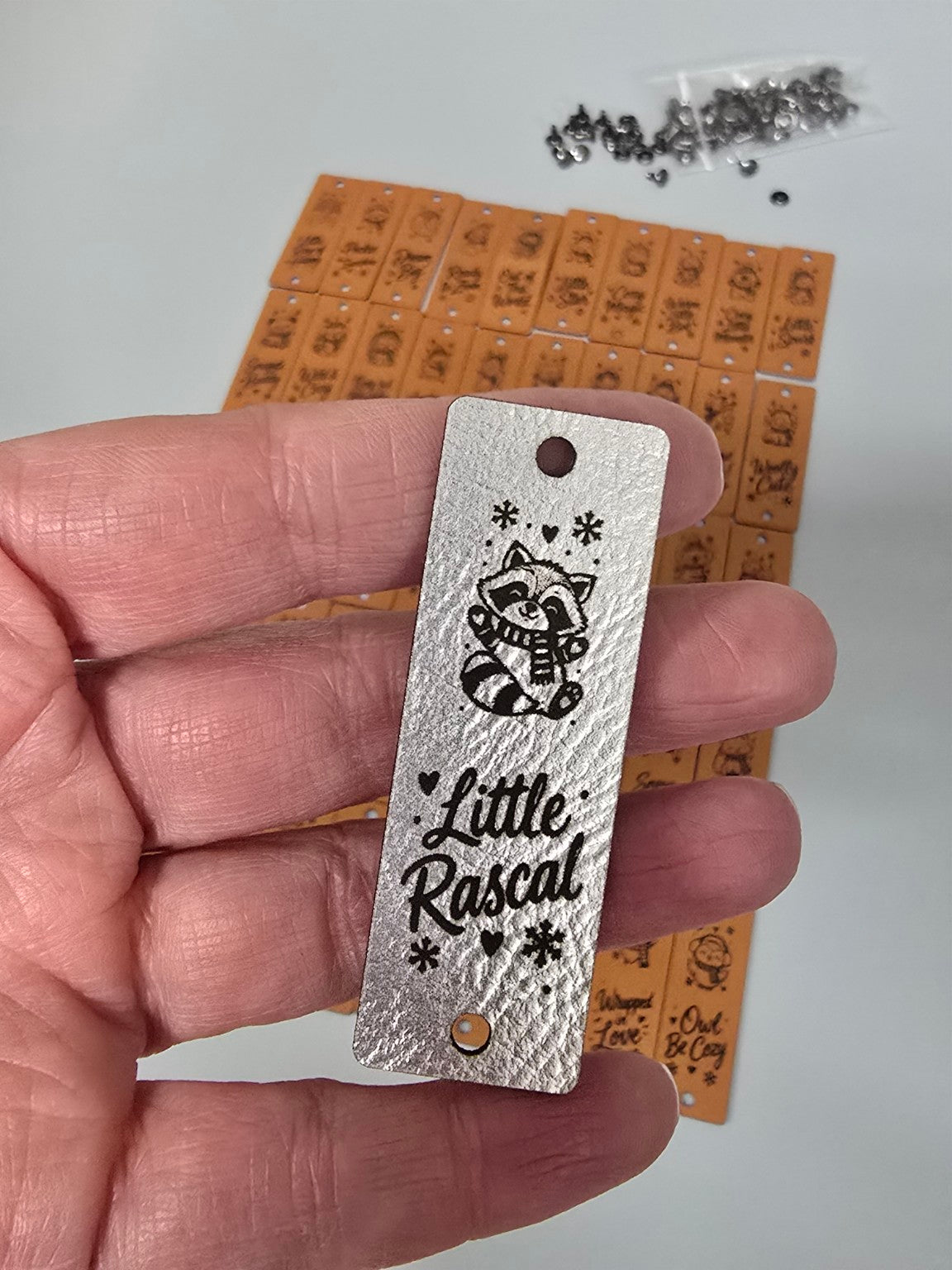 Metallic silver Little Rascal raccoon fold-over tag