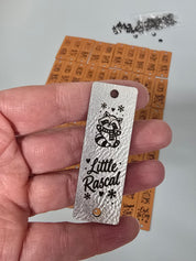 Metallic silver Little Rascal raccoon fold-over tag