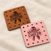 Stronger Than Cancer engraved faux leather sew-on patches on a cream background